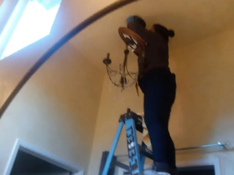 Electrician installing a chandelier in a Youngstown residence